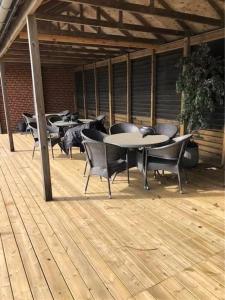 a group of tables and chairs on a wooden deck at Struer udlejning - lejlighed 1 Bredgade 62 C in Struer