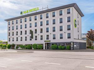 a large white building with a sign on it at B&B HOTEL Saarbrücken-Ost in Saarbrücken