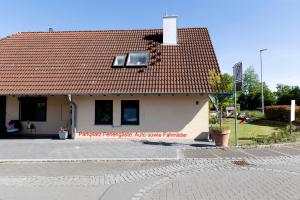 a small white building with a red roof at Wohnung am Bodensee in Moos