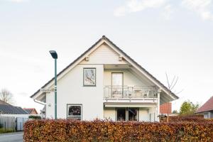 a white house with a gambrel roof at Ferienwohnung Auszeit mit Waldgeflüster 35231 in Hesel