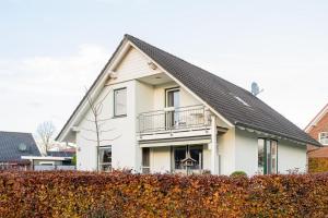 a white house with a black roof at Ferienwohnung Auszeit mit Waldgeflüster 35231 in Hesel +35 photos