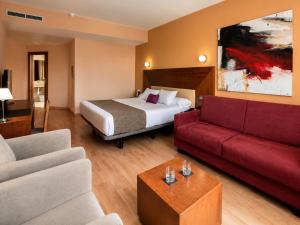 a hotel room with a bed and a red couch at Hotel Andia in Orcoyen +128 photos