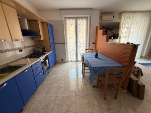 a kitchen with blue cabinets and a table with chairs at House raffy in San Severo
