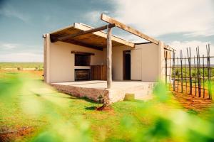a small house in a field with a fence at Nama-Qua Game Reserve in Vredendal