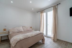 a bedroom with a bed and a large window at Port-la-Nouvelle 4p in Port-la-Nouvelle
