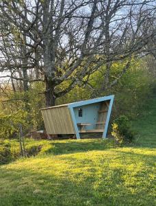 a small building in a field next to a tree at Cabane étape in Idrac-Respailles