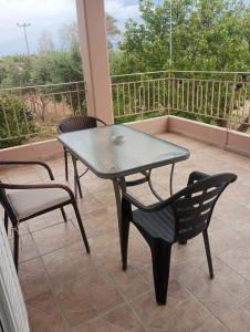 a table and chairs on a porch with a table and chairs at Analipsis Messinis Apartments in Análipsis +18 photos