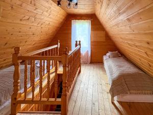 a attic room with a bed and a staircase at Willa Wielka Puszcza in Porąbka