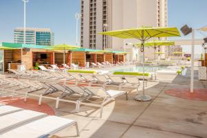 een groep stoelen en parasols op een patio met een zwembad bij Plaza Hotel & Casino in Las Vegas