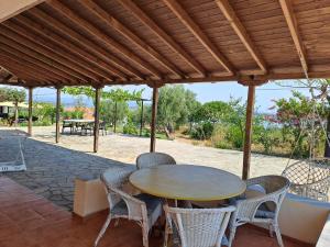 a wooden table and chairs on a patio at Lofos Vourvourou in Vourvourou