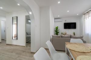 a living room with white walls and a table and chairs at Port-la-Nouvelle 4p in Port-la-Nouvelle