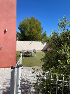 a table and chairs in a garden next to a building at Pitchoun in Velaux