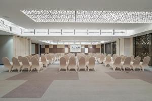 a conference room with white chairs and a sign in the middle at Aston Kemayoran City Hotel in Jakarta +15 photos