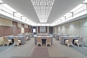 a conference room with white tables and white chairs at Aston Kemayoran City Hotel in Jakarta