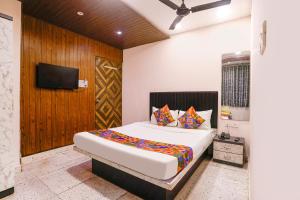 a bedroom with a large bed and a tv at FabHotel Nilsa in Pālghar +31 photos