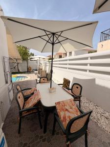 a table and chairs with an umbrella on a patio at Villa Andy-350 m from the beach in Larnaca