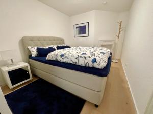 a bedroom with a bed with a blue and white comforter at Appartement Zirbe in Rickenbach