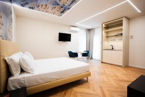 a bedroom with a bed and a table with chairs at Afrodite Luxury Residence & Spa in Pescara