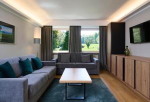 ein Wohnzimmer mit Sofa und Tisch in der Unterkunft Hotel Schloss Berg in Berg am Starnberger See