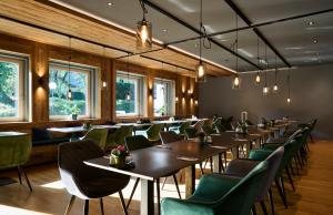 ein Esszimmer mit Tischen und grünen Stühlen in der Unterkunft Hotel Schloss Berg in Berg am Starnberger See