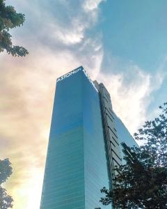 a tall glass building with the sony at Aston Kemayoran City Hotel in Jakarta