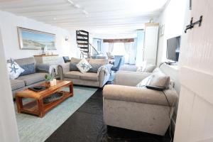a living room with two couches and a table at The Boathouse on the Atlantic Sea in Liscannor