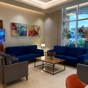 a living room with blue couches and a coffee table at Mandarin Alshamal Hotel Apartments in Riyadh