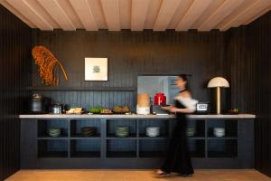 a woman standing in front of a counter with plates at Lijiang Chenxi View Hotel in Lijiang