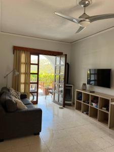 a living room with a couch and a flat screen tv at The Citrus Valley in Pissouri