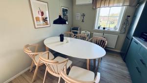 a dining room with a white table and chairs at Skog Fegen nära Ullared in Fegen