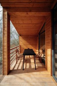 a wooden porch with a table and benches on it at УЛІС Віняви in Derevach