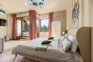 a bedroom with a bed and a large window at Woodland Apartment in Silver Mountain Resort in Poiana Brasov +51 photos