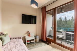 a bedroom with a bed and a sliding glass door at Woodland Apartment in Silver Mountain Resort in Poiana Brasov