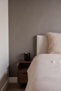 a bedroom with a bed and a nightstand with a candle at Spacious family home in Schiedam