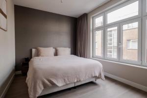 a bedroom with a bed and a large window at Spacious family home in Schiedam