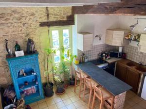 a kitchen with a table and a blue cabinet at Maison Périgourdine familiale in Saint-Jean-dʼEyraud