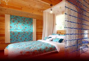 a bedroom with a bed with a blue wall at dagagada pension in Hwach'ŏn