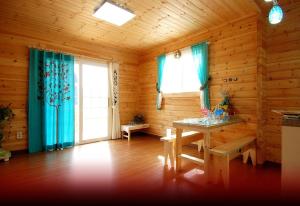 a wooden room with a table and blue curtains at dagagada pension in Hwach'ŏn