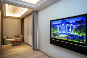 a living room with a flat screen tv on a wall at Mercure Changchun Ziyou Road Dahua in Changchun