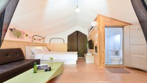 a living room with a bed and a bathroom at Gapyeong Gratia glamping in Gapyeong