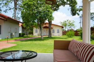 a couch and a glass table in front of a house at La Villa des Chien in Ban Nong Chap Tao