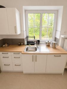 a kitchen with white cabinets and a sink and a window at Apartment Rahden in Rahden
