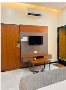a living room with a tv and a coffee table at Hotel Legend's Aurangabad in Aurangabad