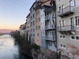 a row of apartment buildings next to a river at Flusshaus BnB Okavango in Brugg