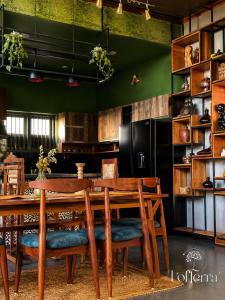 a dining room with a table and a black refrigerator at Lofterra Luxury Apartment in Kozhikode city, calicut in Kozhikode