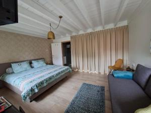 a bedroom with a bed and a couch at De Lokroep in Heers