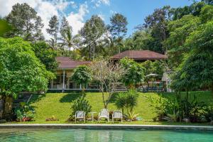 a house with chairs and a swimming pool at Urbanview Onengan Resort in Palang-Putih