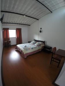 a bedroom with a bed and a table and chairs at Hotel Tacuara in Guaduas