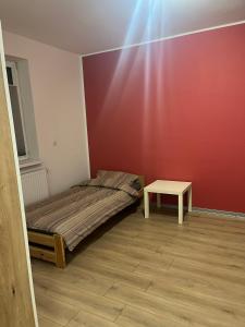 a small bedroom with a bed and a table at Apartament przy kortach 3 in Bytom