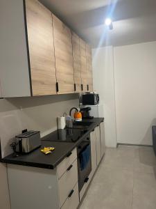 a kitchen with white cabinets and a black counter top at Apartament przy kortach 3 in Bytom